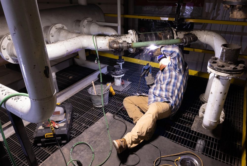 Student welding inside the pipeline simulator