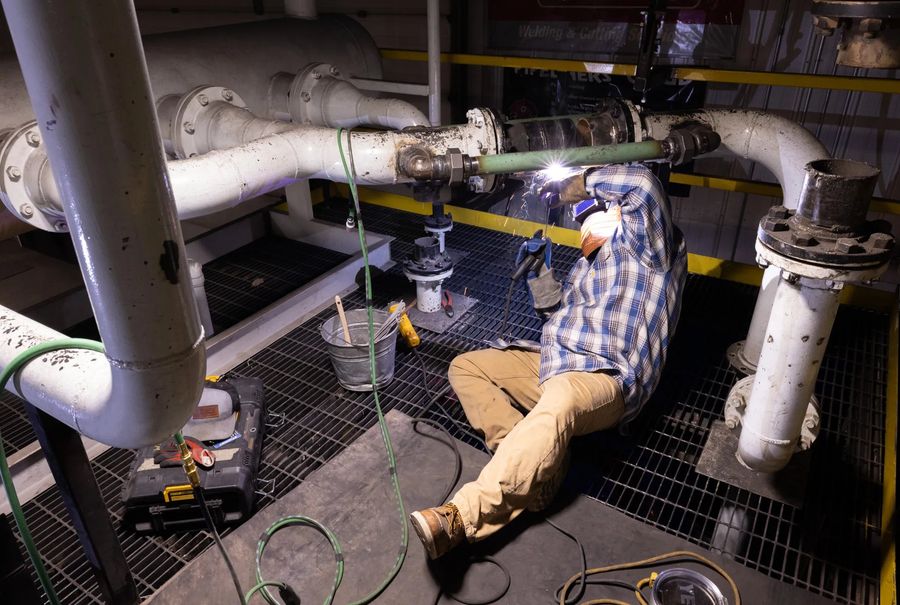 Student welding inside the pipeline simulator