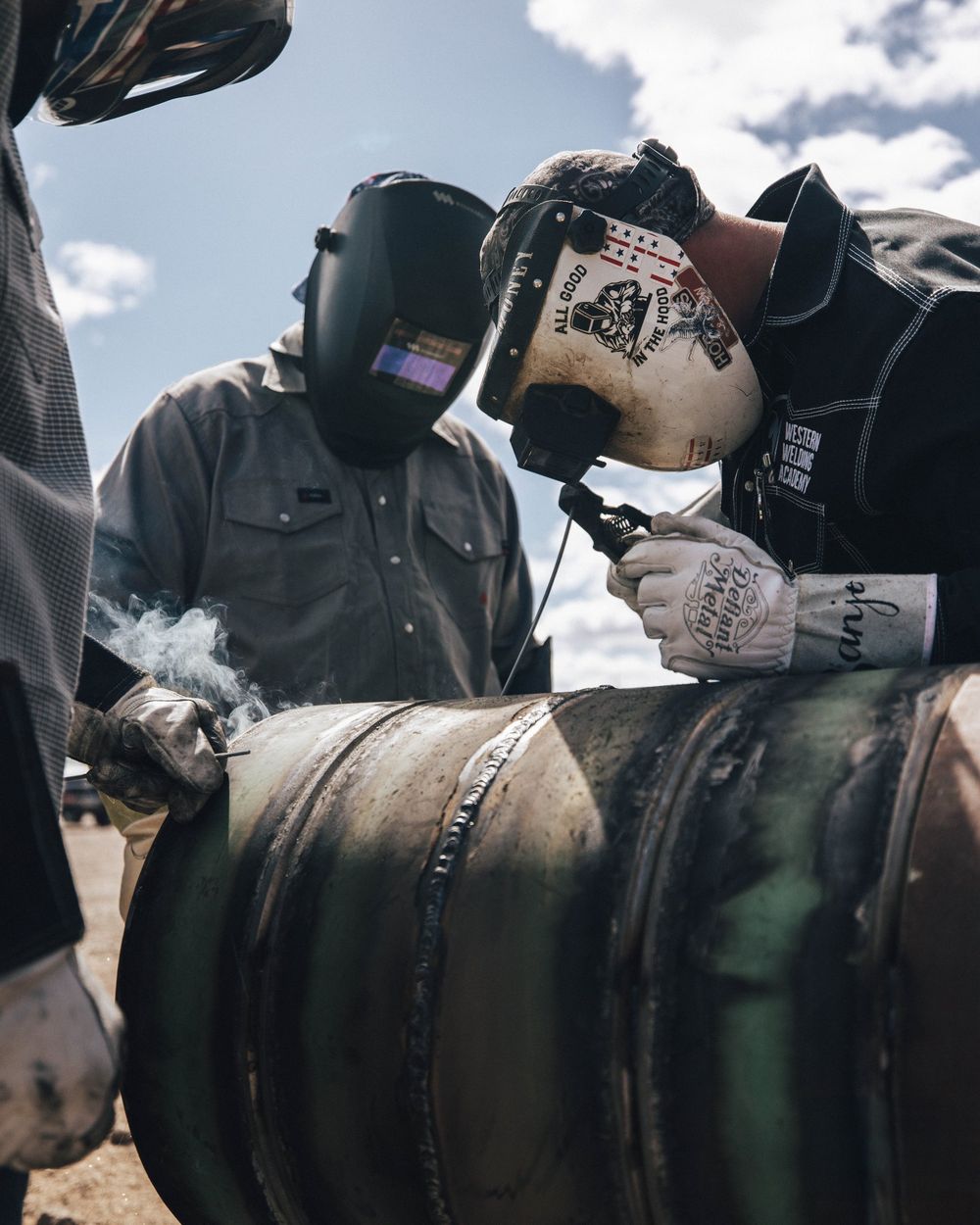 Welder in a WWA hood running a pass on pipe